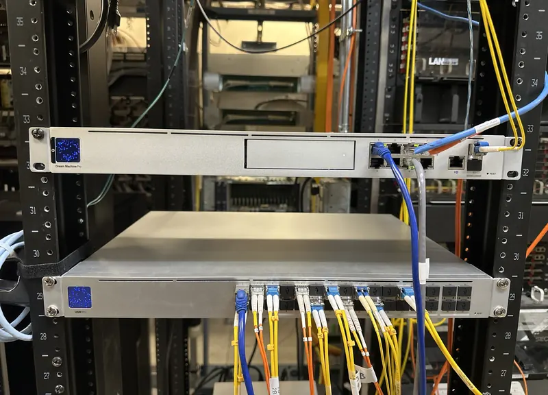 Chandler Park computer room: UniFi Dream Machine Pro above a USW Pro Aggregation switch with labeled single-mode and multimode fiber patched into its SFP ports